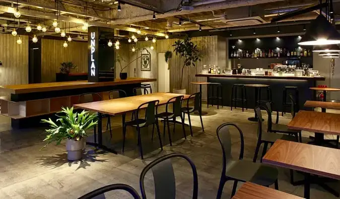 L'elegante lounge con molti tavoli in legno presso Unplan Kagurazaka a Tokyo, in Giappone