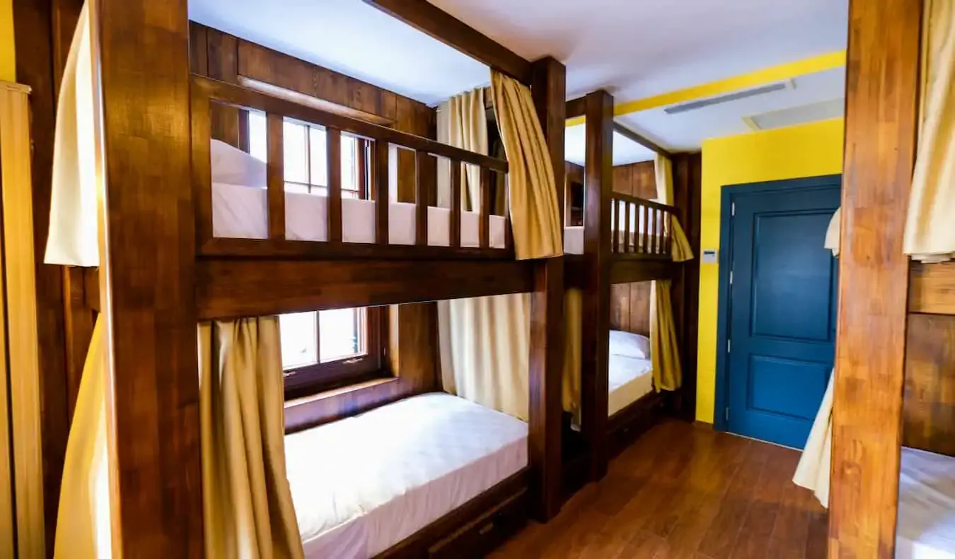 L'interior del Yolo Hostel a Istanbul, Turquia, amb lliteres de fusta i cortines en un dormitori petit