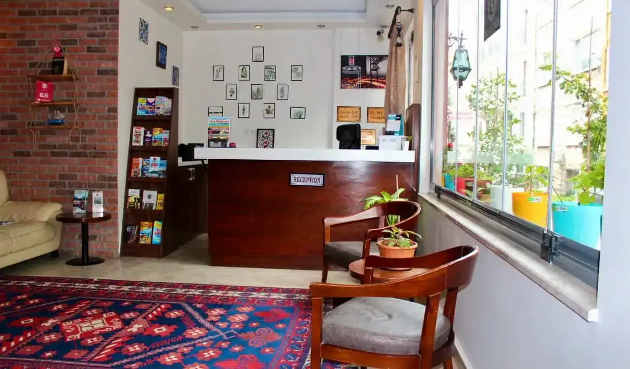 Ang front desk ng Stanpoli Hostel, na may makulay na carpet malapit sa pasukan sa Istanbul, Turkey