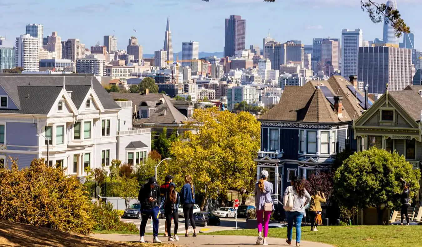 Mga taong naglalakad sa maaraw na San Francisco na may matayog na downtown sa di kalayuan