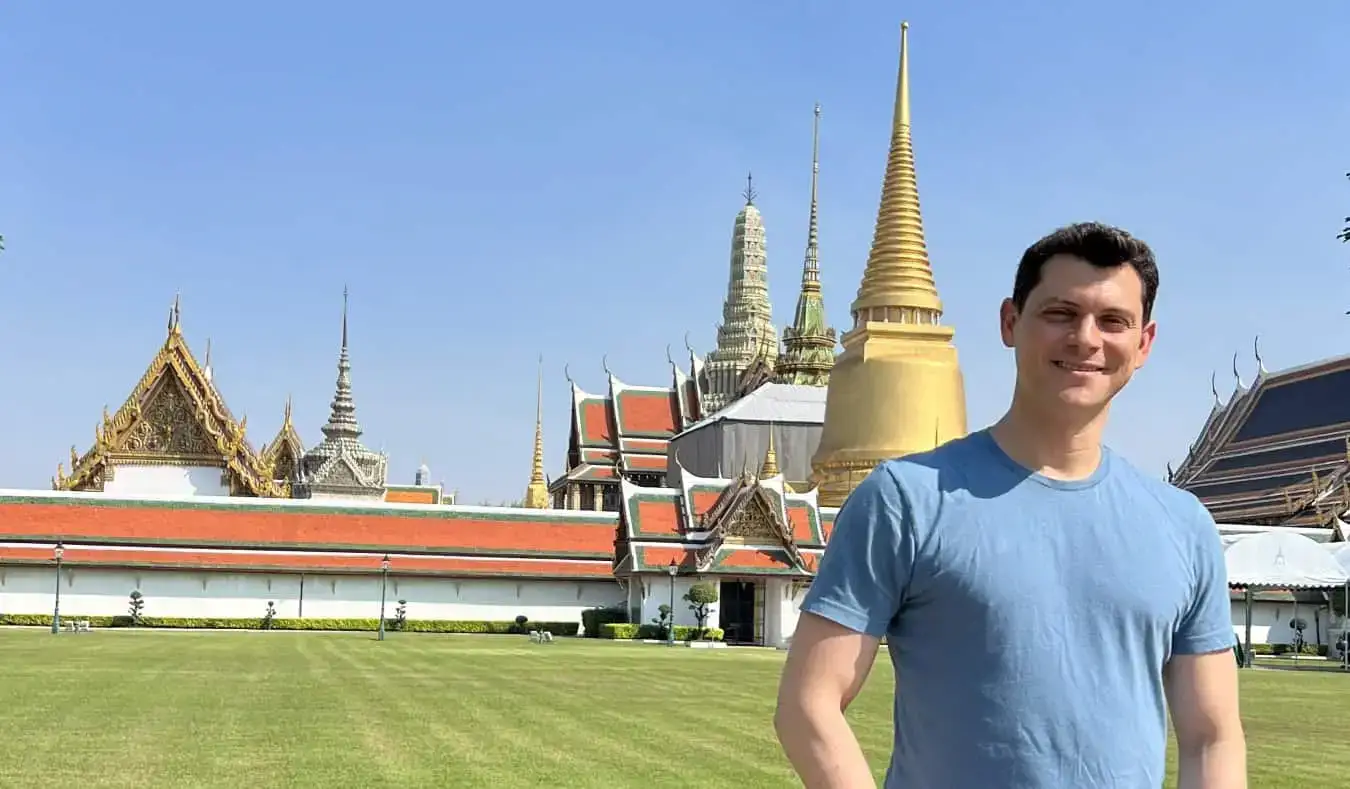 Nomadic Matt parado frente a un templo en Tailandia