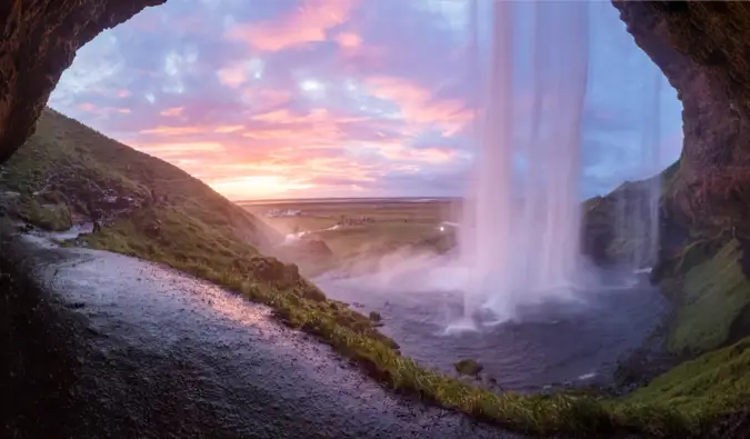 Isang magandang talon sa tabi ng isang masungit na tanawin sa maaraw na Iceland