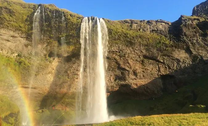 Framsidan av Seljalandsfoss med en isländsk regnbåge