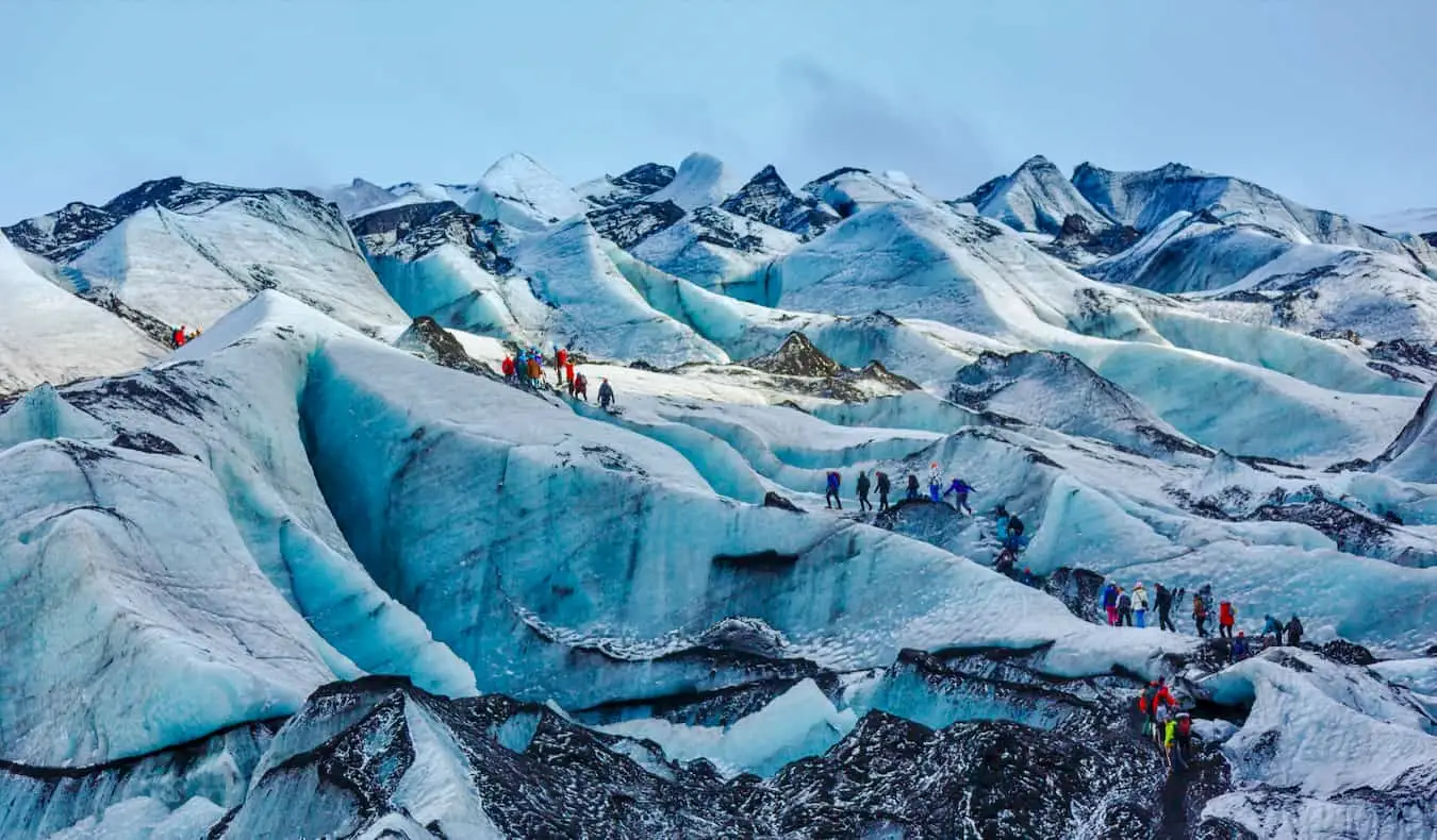 Persone che fanno escursioni su uno splendido e massiccio ghiacciaio nell'aspra Islanda