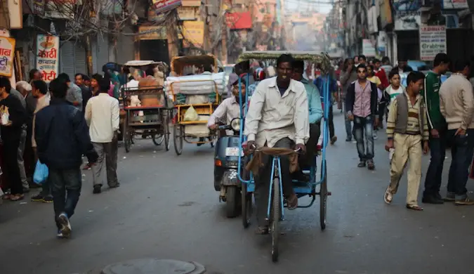 un carrer concorregut d'una ciutat índia, ple de gent i rickshaws