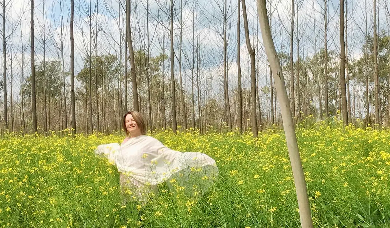 Seorang wanita solo di India bergambar di padang hijau yang dikelilingi oleh rumput dan pokok