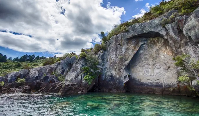 Mural Maori yang diukir pada batu dekat perairan di Selandia Baru