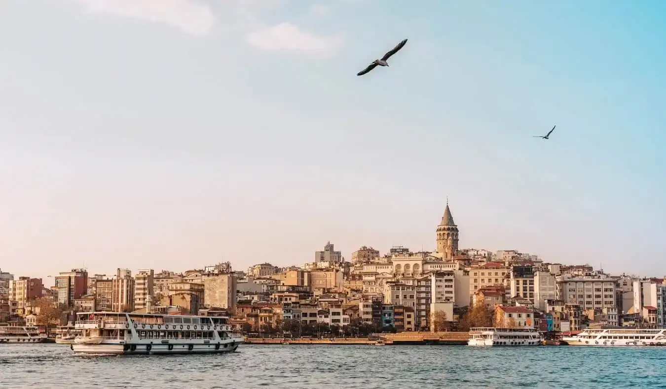 Vista das balsas no rio Bósforo ao pôr do sol, com a Torre Galata erguendo-se acima do horizonte de Istambul