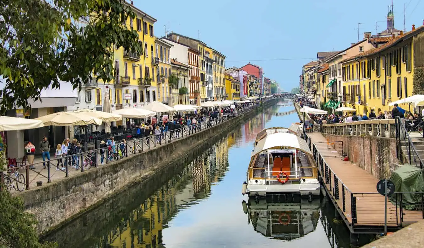 Un canal îngust mărginit de cafenele și restaurante aglomerate din Milano însorit, Italia