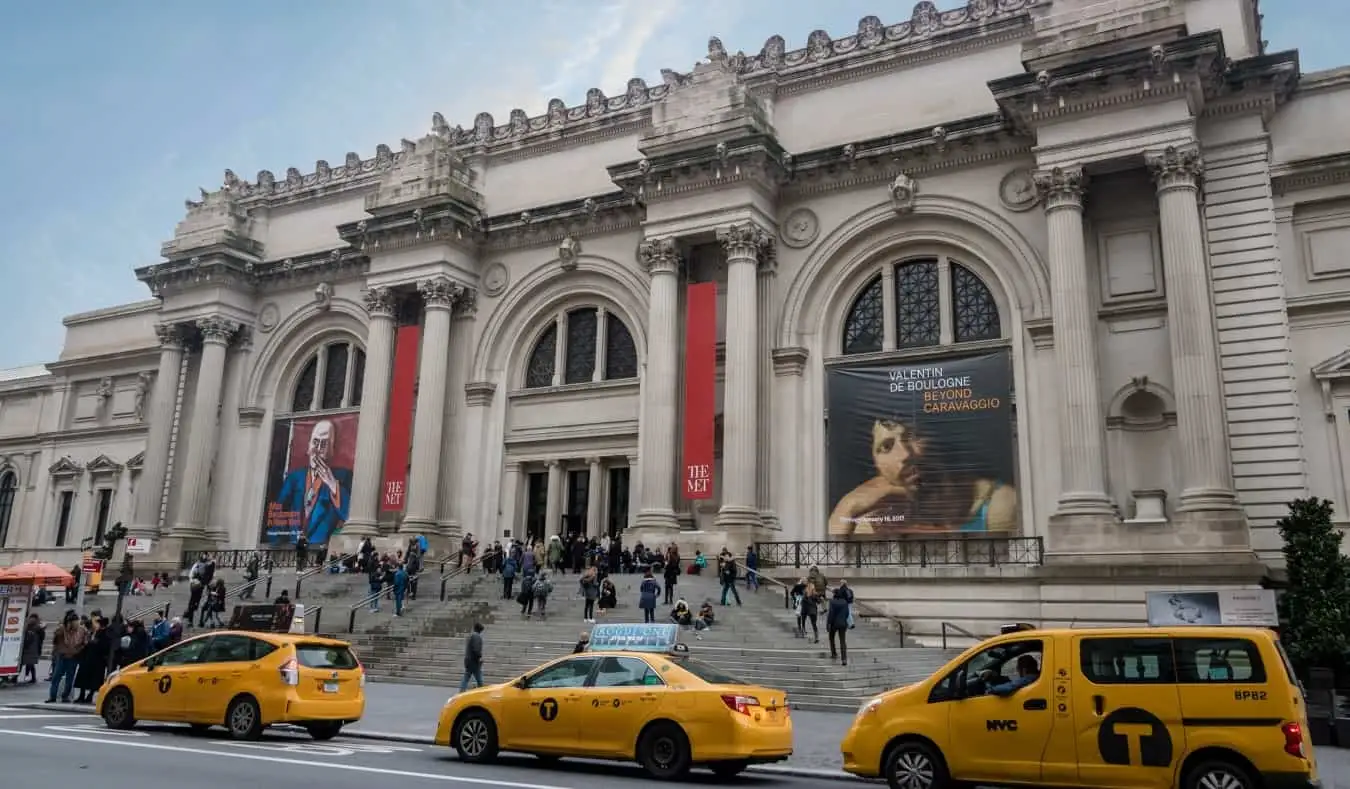 Teksi kuning di hadapan tangga yang luas di Muzium Seni Metropolitan di NYC, Amerika Syarikat