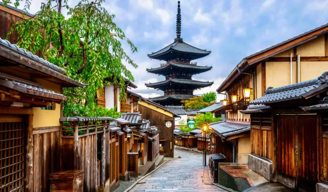 En smal, gammel gade i stille Kyoto, Japan med en pagode i det fjerne