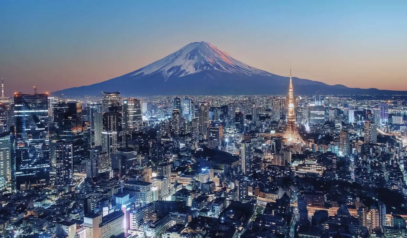 Razprostranjeno obzorje Tokia na Japonskem je ponoči osvetljeno z goro Fuji v daljavi