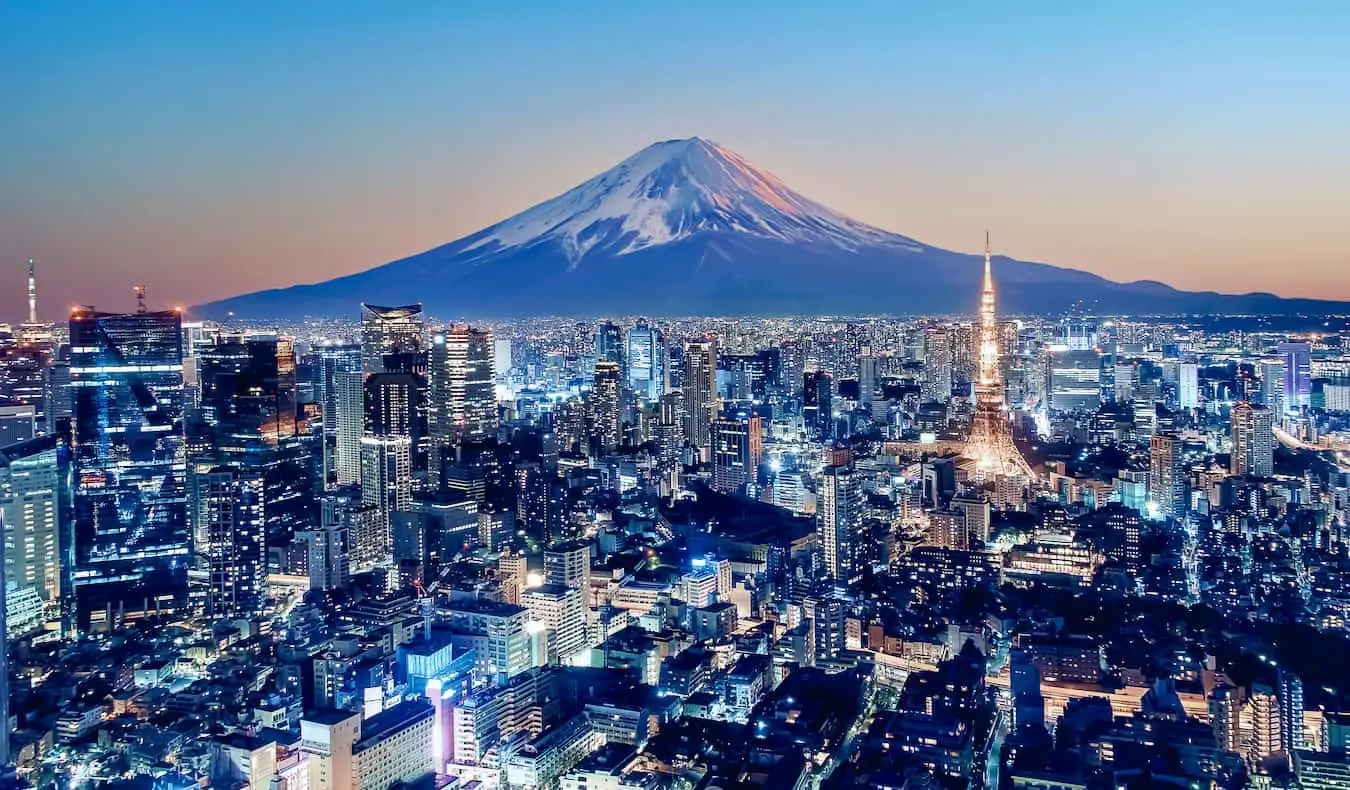 Una vista de Tokio, Japón por la noche con el Monte Fuji al fondo