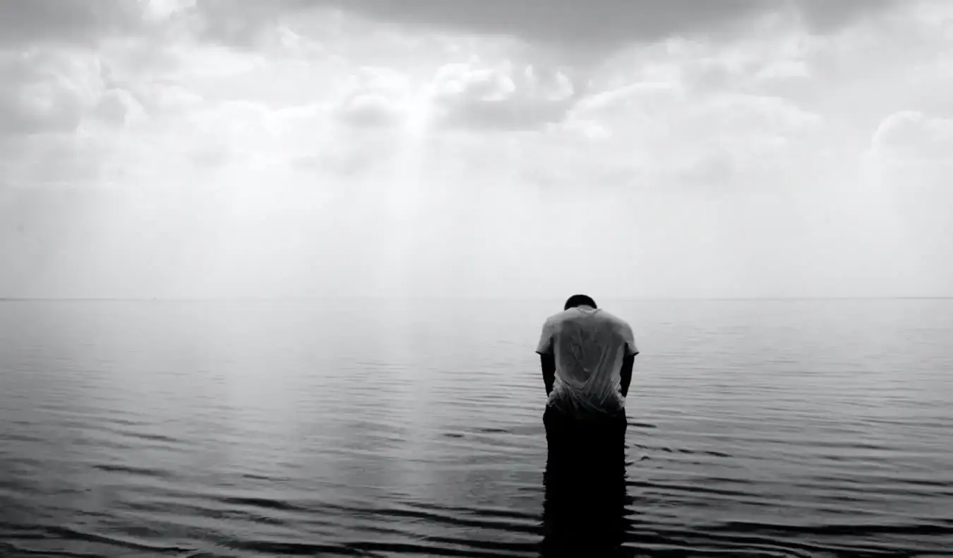 Ein Schwarz-Weiß-Foto eines einsamen Reisenden allein im Wasser