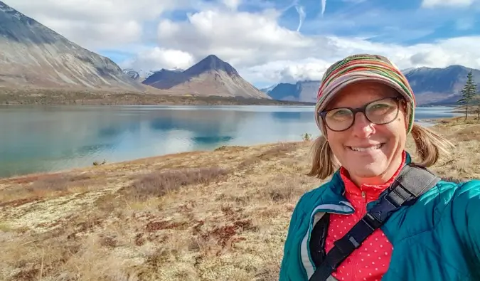 Sherry Ott parada frente a pintorescas montañas