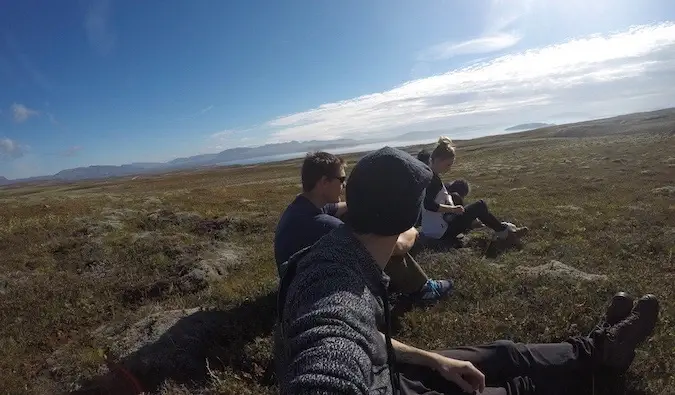 Een groep reizigers op een roadtrip die lunchen in het gras