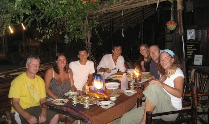 Amigos que viajan comiendo juntos en un albergue en Tailandia