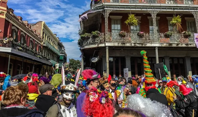 Participanții la Mardi Gras costumați pe Bourbon Street