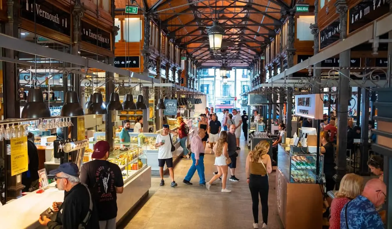 Madrid, İspanya'daki tarihi kapalı pazar Mercado de San Miguel'in koridorlarında yürüyen insanlar