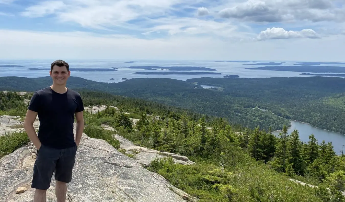 Nomadic Matt pózuje pro fotografii v národním parku Acadia, Maine