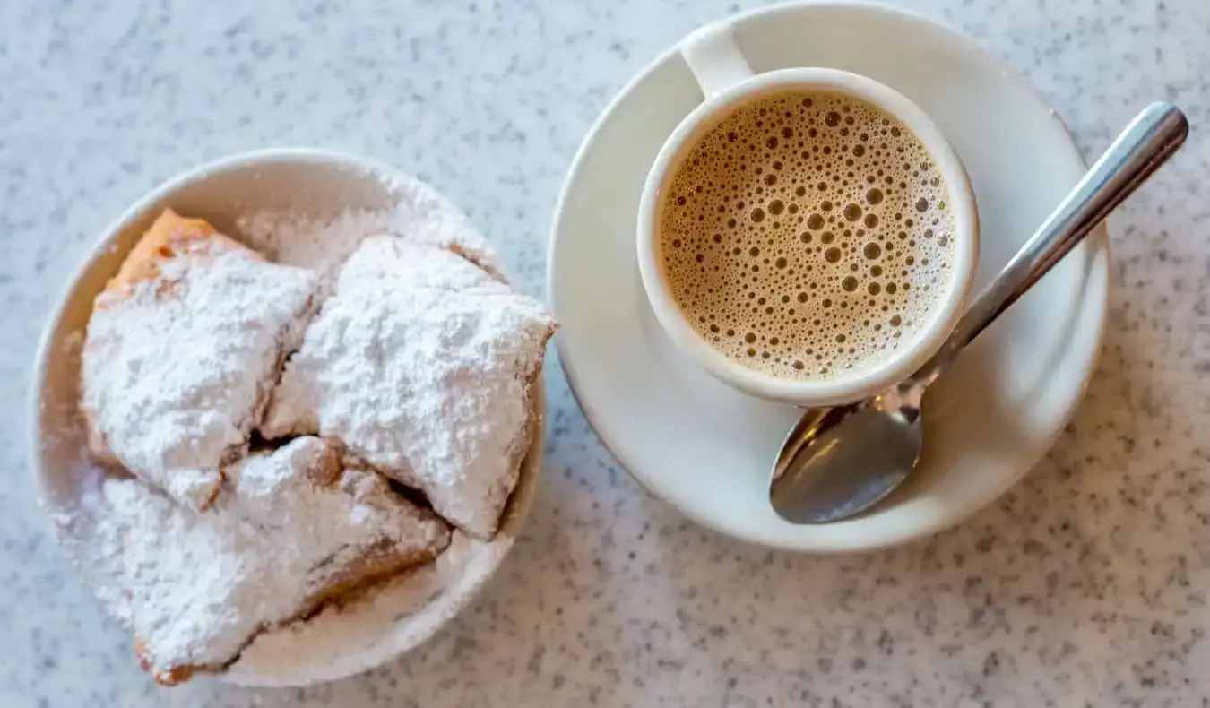 Ein Kaffee und kleine frittierte Snacks auf einem Tisch in New Orleans, USA