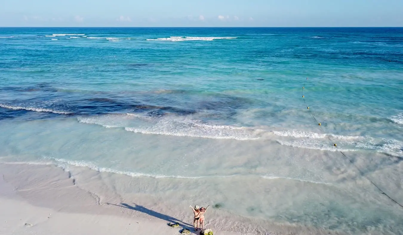 Kvindelig solorejsende Kristin Addiss i Mexico med en ven på stranden og kigger ud over vandet