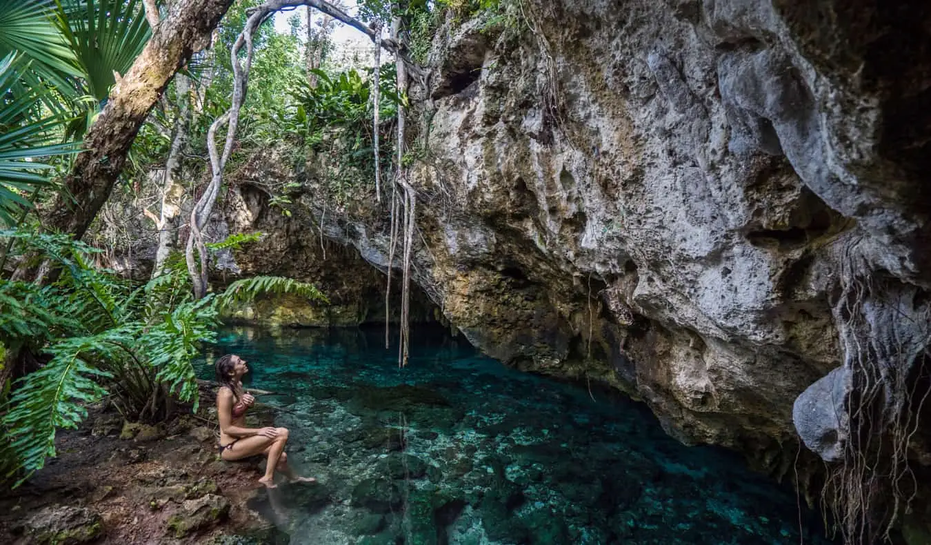 Vrouwelijke soloreiziger Kristin Addiss in Mexico, ontspannend bij een junglecenote