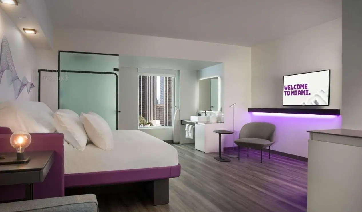 Quarto de hotel com design minimalista e cores roxas no Yotel em Miami, Flórida