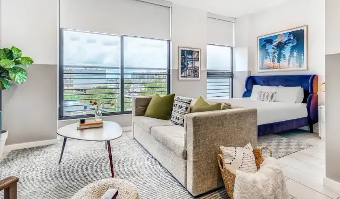 Tempat tidur dan sofa di apartemen dengan jendela setinggi langit-langit di aparthotel Sentral Wynwood di Wynwood, Miami