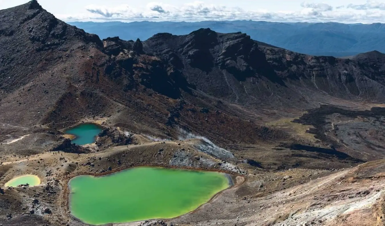 Smaragdzöld tavak a Tongariro Alpine Crossing éles vulkáni táján, egy túra Új-Zélandon