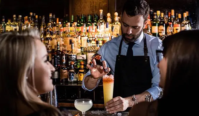 Um barman serve coquetéis sofisticados para clientes do Death and Company em Nova York