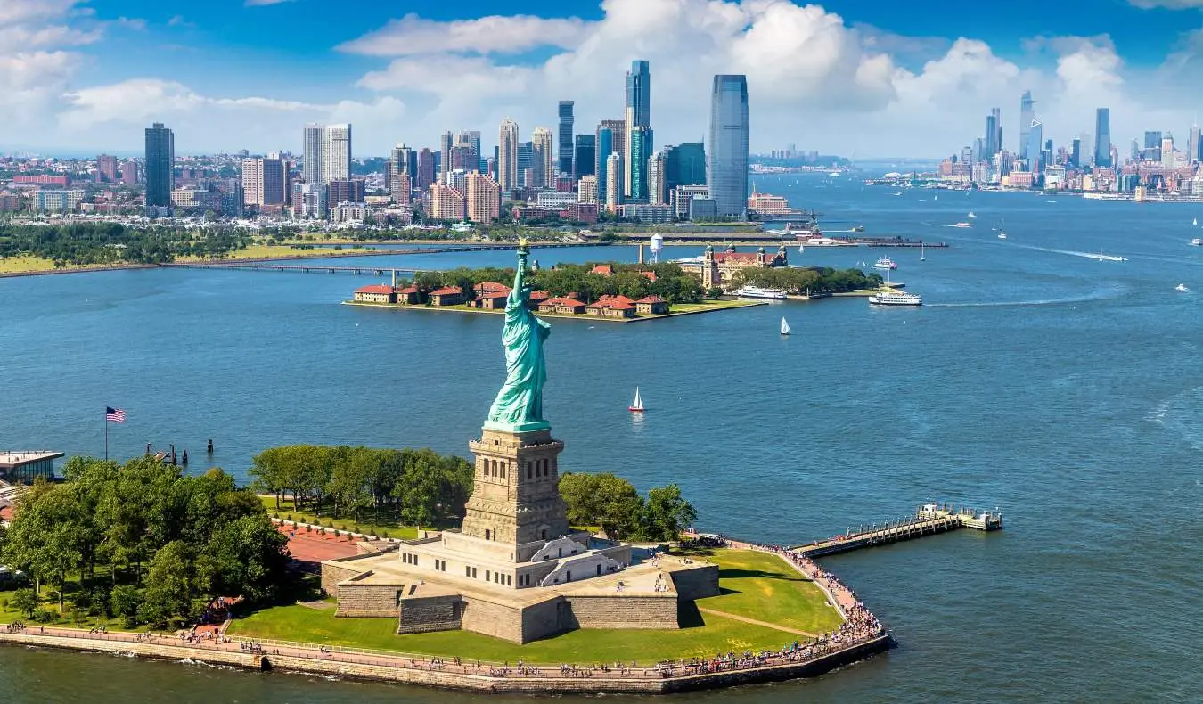 Panoramaudsigt fra luften Frihedsgudinden og med skylines af Manhattan og Jersey City i baggrunden