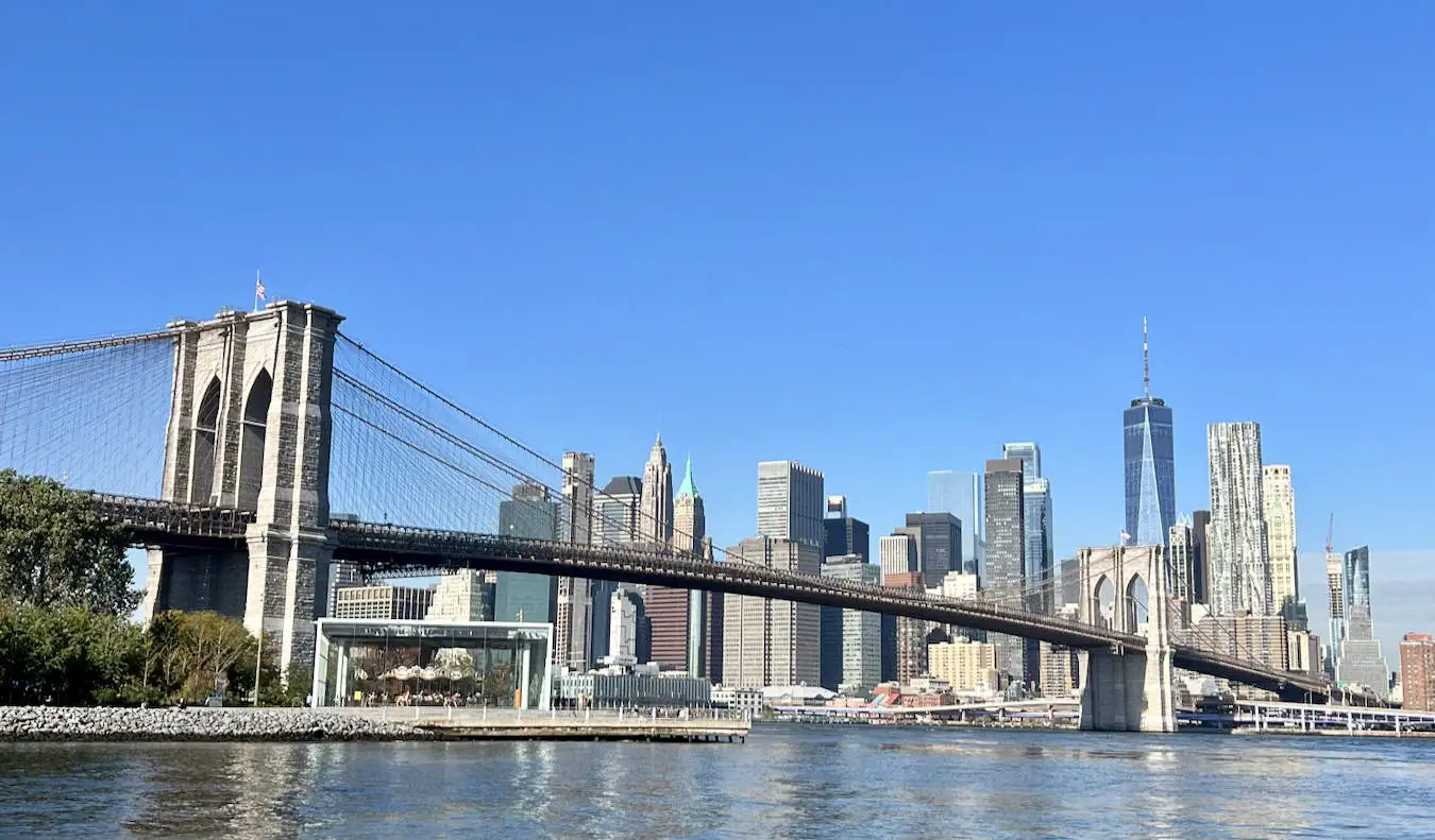 Manhattan, NYC'nin yükselen silüetine bakan mavi bir gökyüzü ve güneşli bir gün