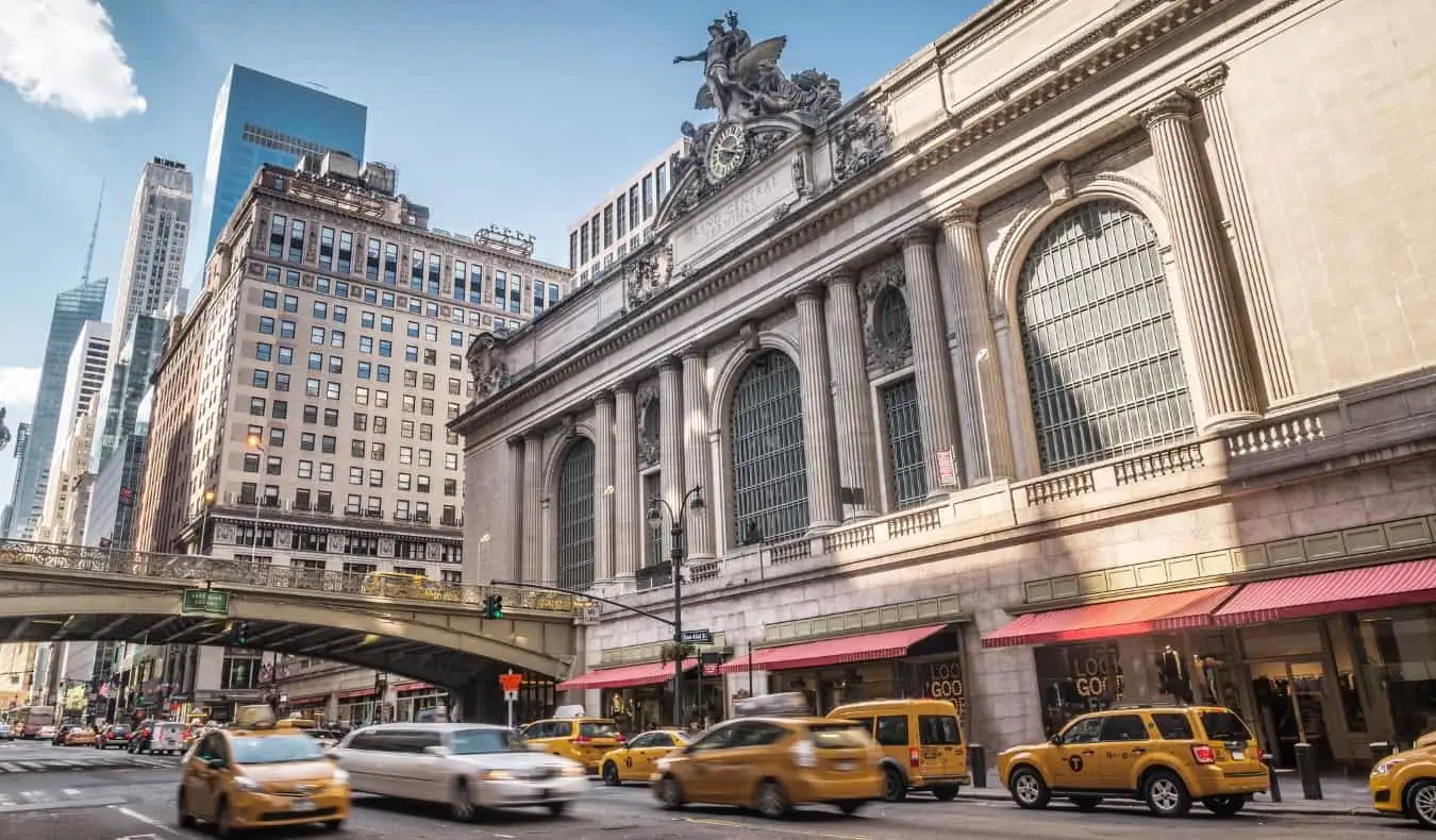 Utsidan av Grand Central Terminal med många gula taxibilar som går nerför gatan framför den i New York City