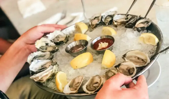 østers blir servert til et bord i en travel restaurant i NYC, USA