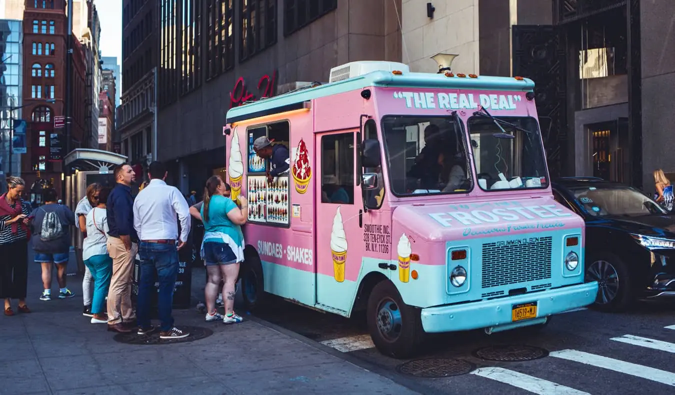 rozā Real Deal pārtikas kravas automašīna, kas ir aizņemta ar ēdienu NYC