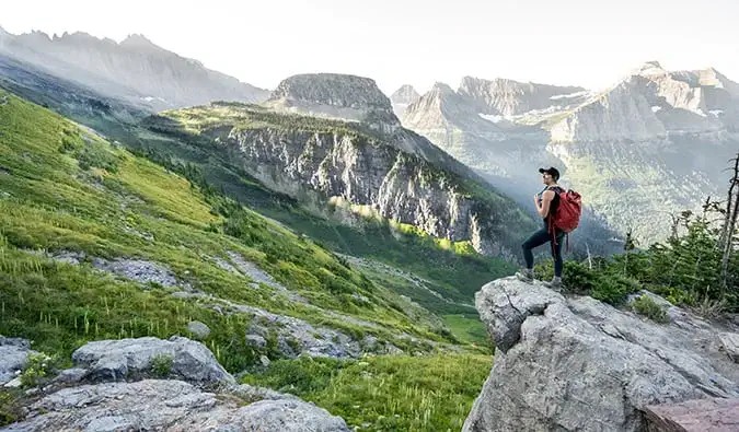 Nữ du khách một mình đi bộ đường dài ở vùng nông thôn xinh đẹp Montana, Mỹ đeo ba lô du lịch