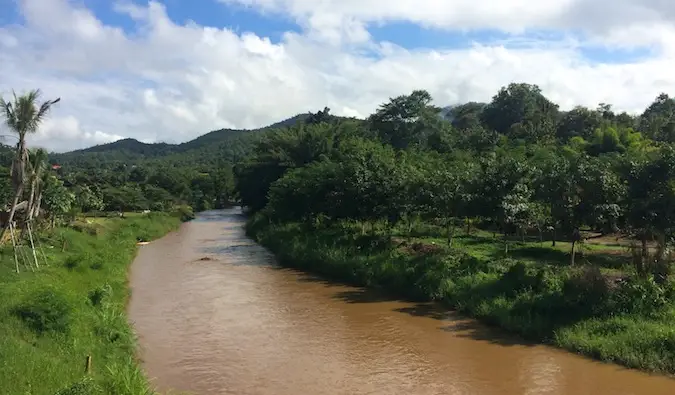 Isang maitim na kayumangging ilog na dumadaloy malapit sa Pai, Thailand