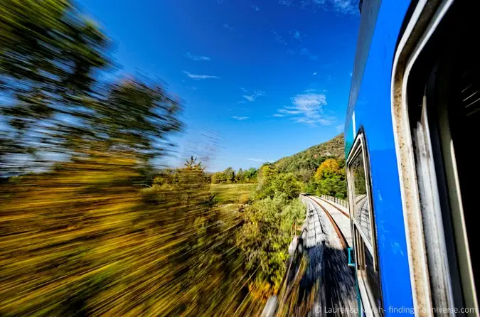 Yemyeşil bir manzaranın önünden geçen hızlı trenin fotoğrafı