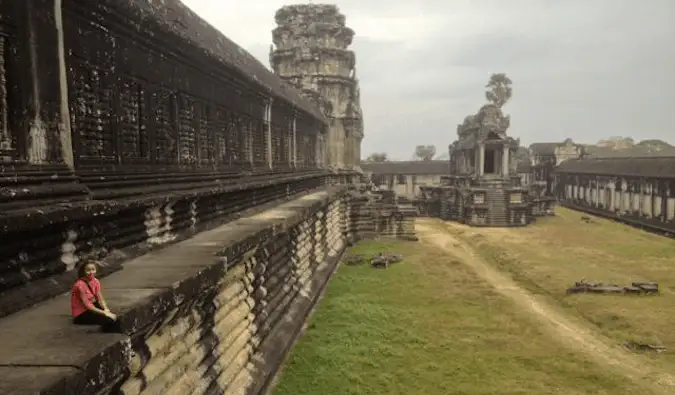 Een solovrouw die zich voordeed op de stenen van Angkor Wat in Cambodja