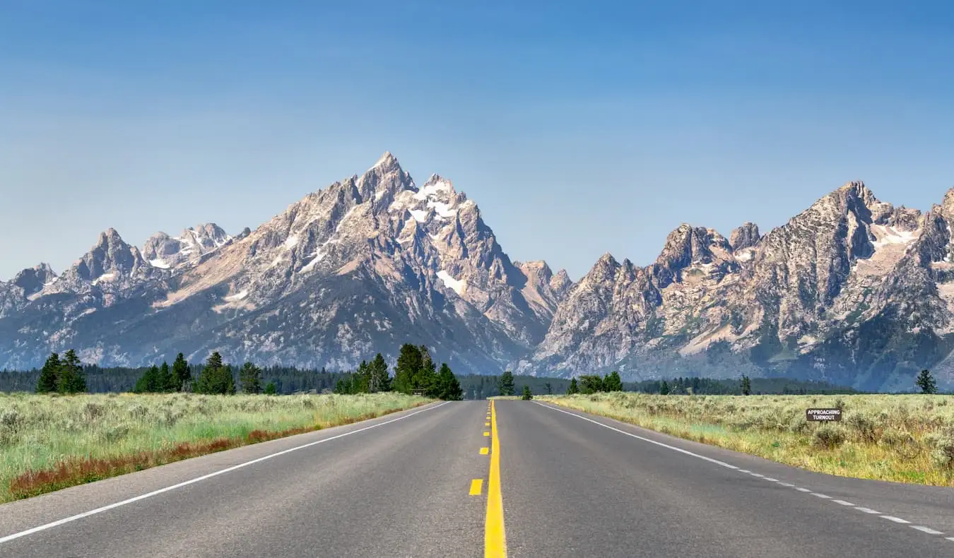 La carretera oberta en un dia assolellat a Wyoming, EUA, amb muntanyes al fons