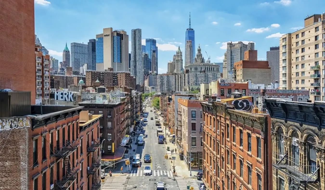 New York City gezien vanaf de Manhattan-brug, met huurkazernes op de voorgrond en moderne wolkenkrabbers op de achtergrond