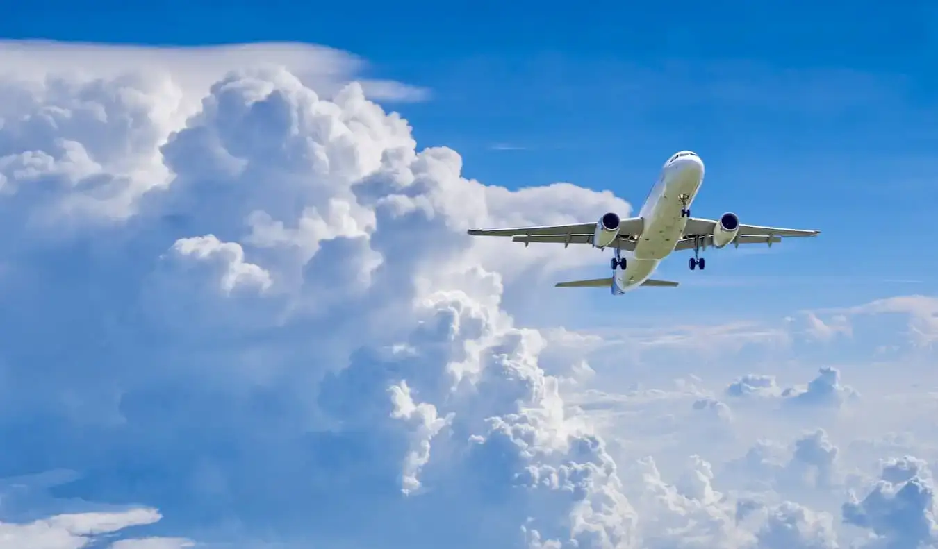 Sebuah kapal terbang komersial terbang di langit biru terang