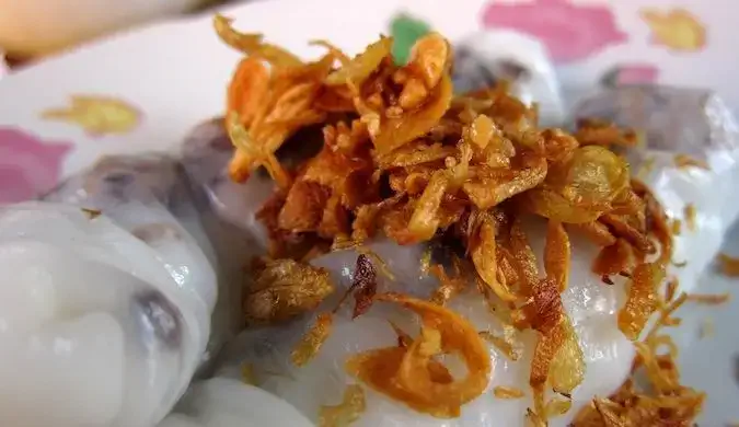 voyager et manger des rouleaux de printemps au porc cuit à la vapeur et aux champignons garnis d'ail frit à Muang Ngoi, Laos