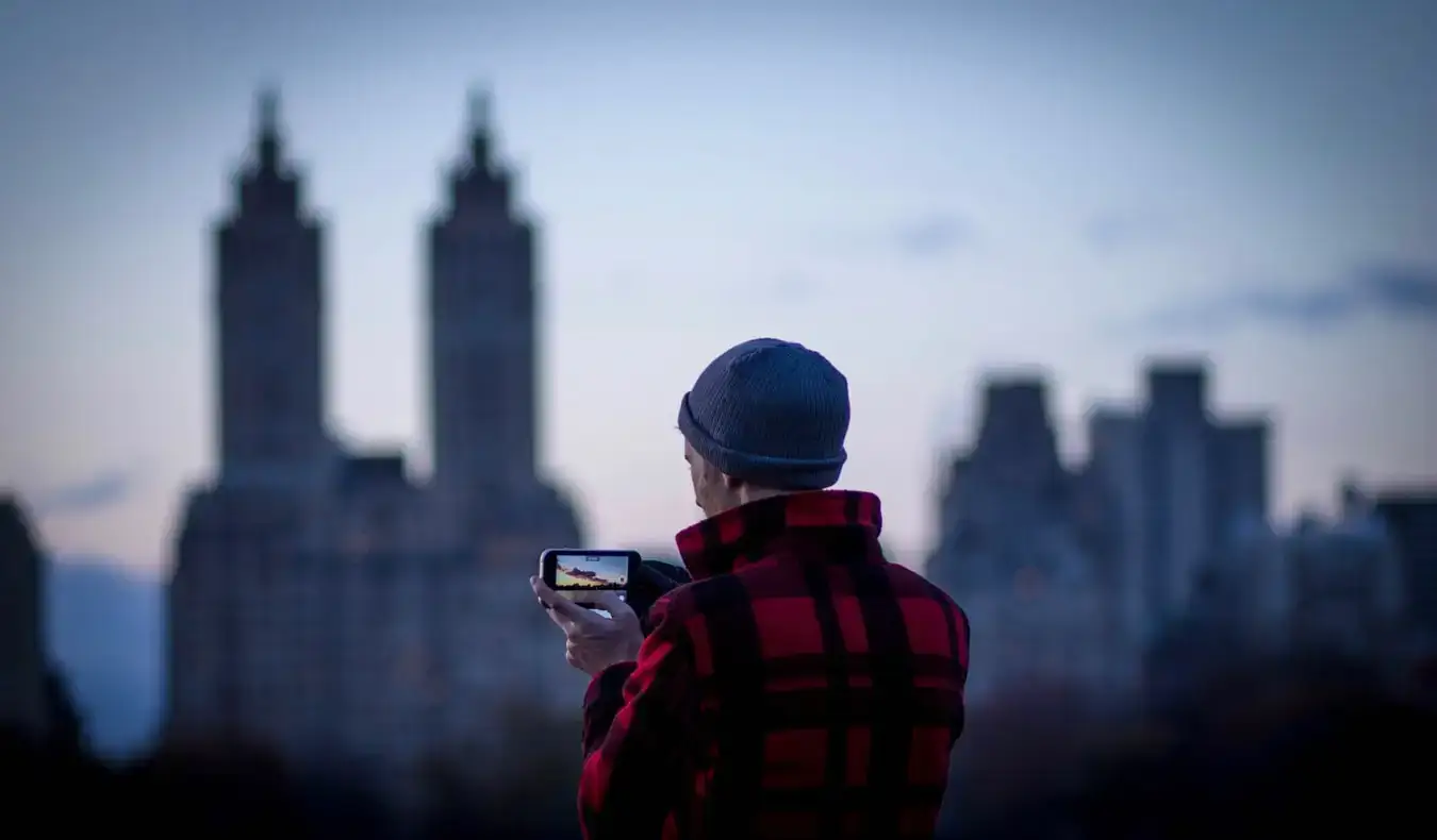 Un voyageur prenant une photo avec un smartphone au coucher du soleil