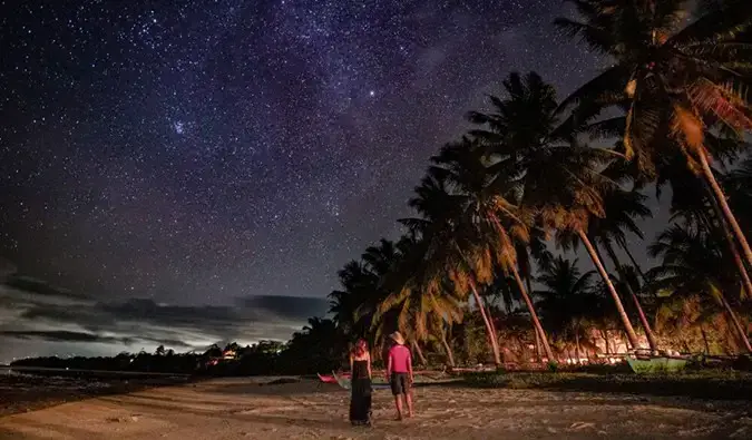 Kristin, eine alleinreisende Frau, trifft sich mit einem Einheimischen an einem Strand im Ausland