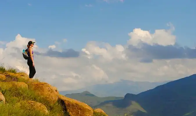 Seyahat ederken Tabel Dağı'nın zirvesinde gün batımına ve bulutlara bakan kadın