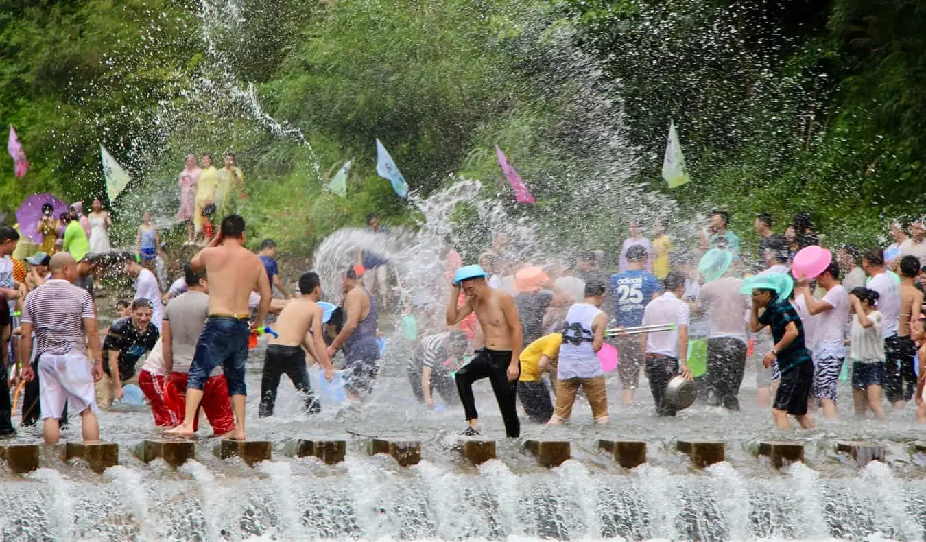 Emberek, akik vízi harcot folytatnak Songkran, a thai újév idején