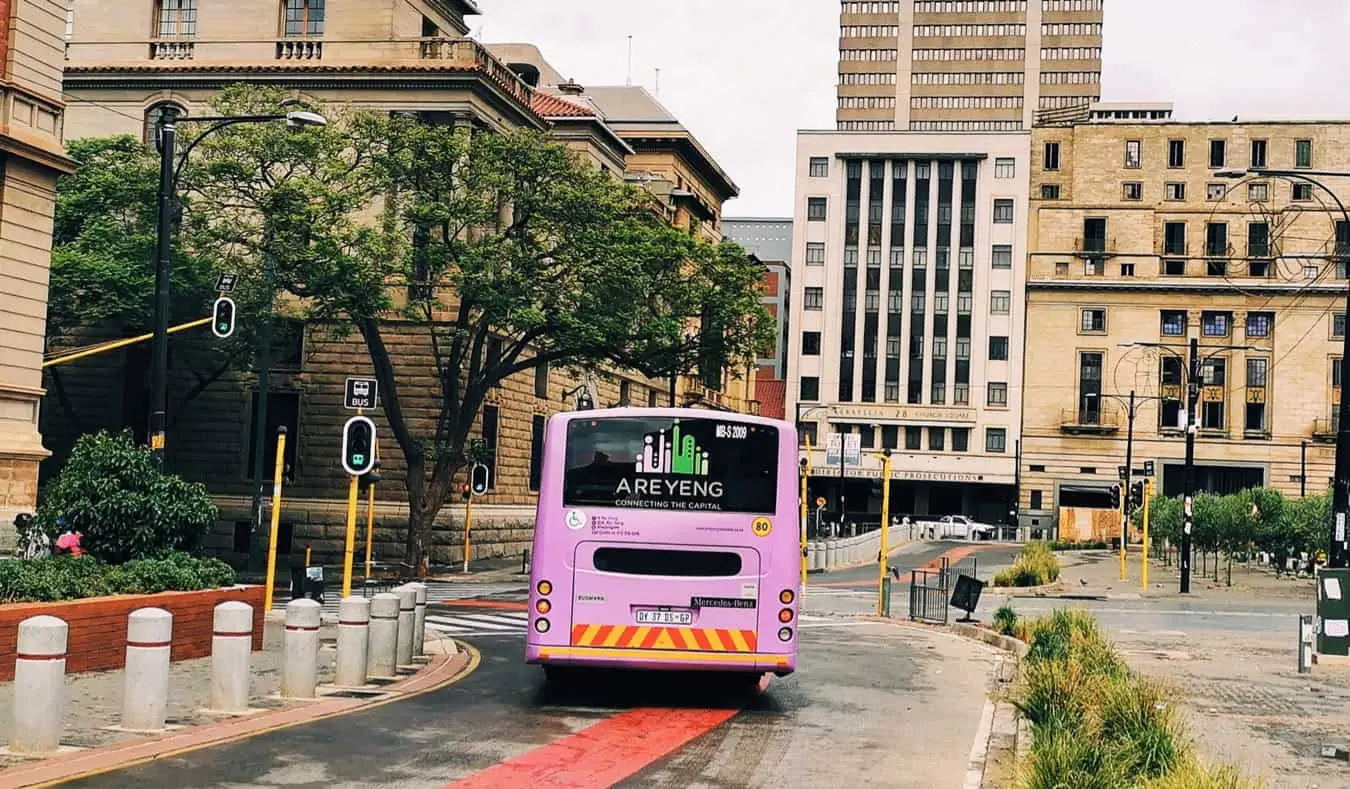 Een touringcar rijdt in een stad in Zuid-Afrika