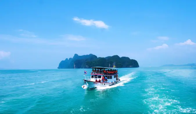 sebuah kapal antar-jemput kecil di Thailand yang melaju menjauh dari sebuah pulau kecil.